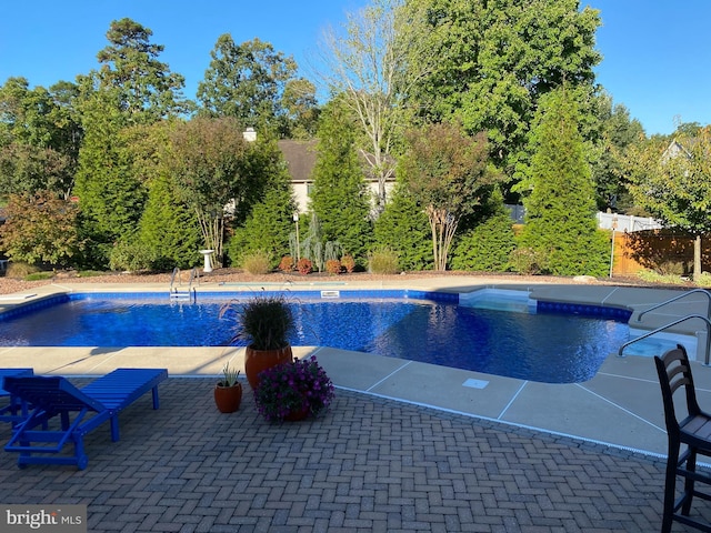 outdoor pool with a patio and a fenced backyard