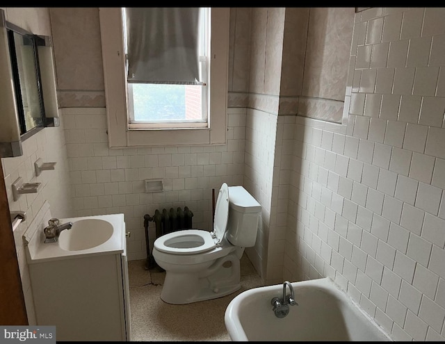 bathroom featuring tile walls, a bath, vanity, and toilet