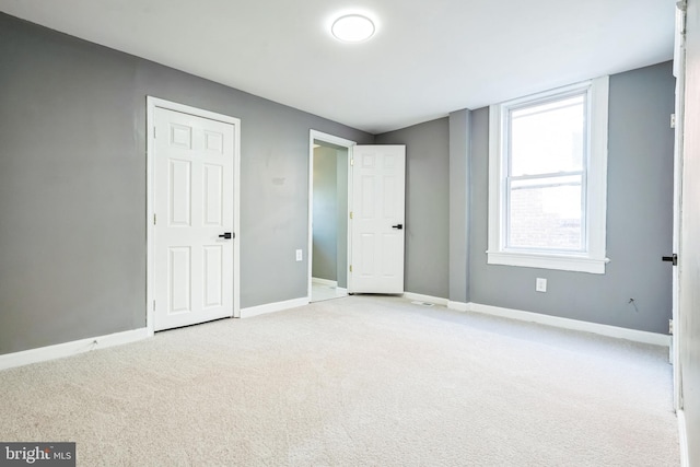 unfurnished bedroom featuring light carpet