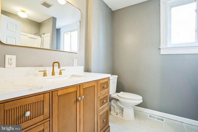 bathroom with tile patterned floors, toilet, vanity, and a shower