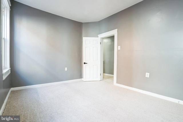 unfurnished room featuring light colored carpet