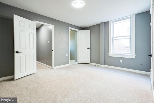 unfurnished bedroom featuring light carpet