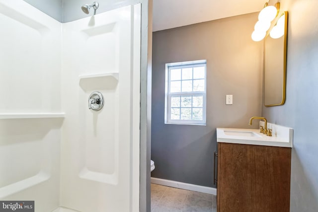 bathroom with toilet, tile patterned floors, vanity, and walk in shower