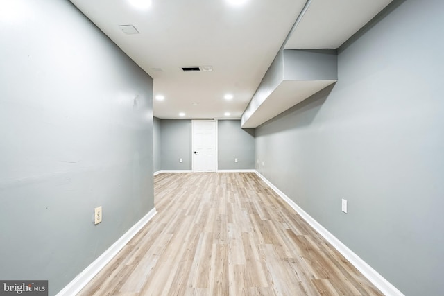 basement with light hardwood / wood-style floors