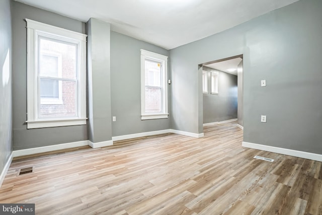 empty room featuring light wood-type flooring and plenty of natural light