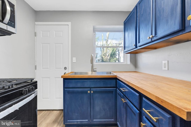 kitchen featuring sink, blue cabinetry, and butcher block counters