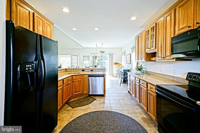 kitchen with glass insert cabinets, brown cabinets, a peninsula, black appliances, and a sink