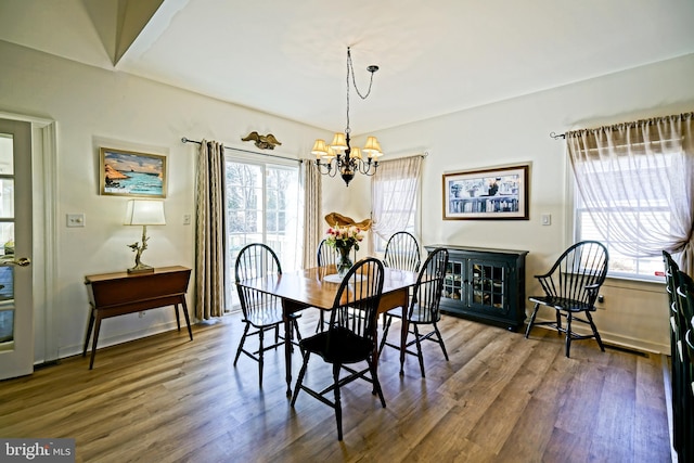 dining room featuring wood finished floors and a chandelier