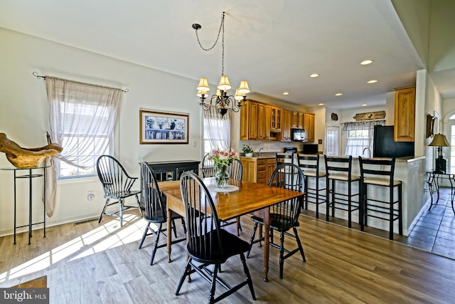 dining room with an inviting chandelier, wood finished floors, and a wealth of natural light