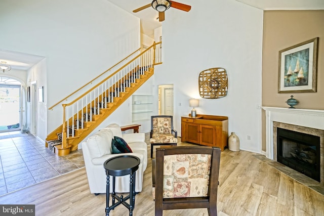 living area featuring stairs, ceiling fan, and wood finished floors