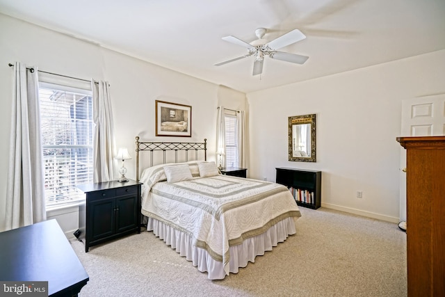 bedroom with baseboards, multiple windows, light carpet, and ceiling fan