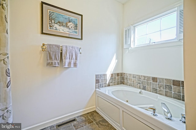 bathroom featuring a tub with jets, visible vents, and baseboards