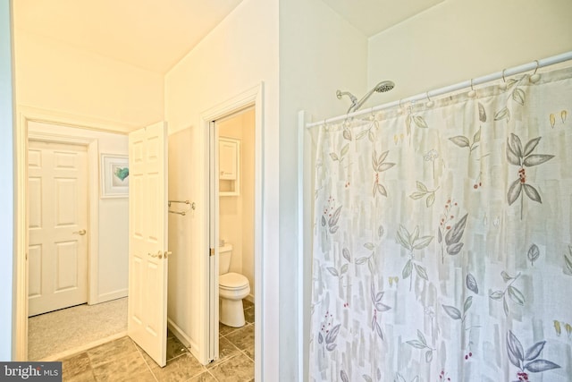 bathroom with tile patterned floors, toilet, and a shower with curtain