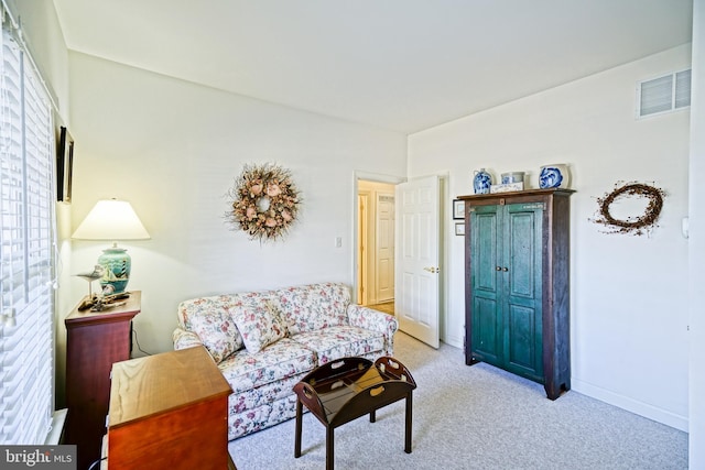 living room featuring visible vents, baseboards, and light colored carpet