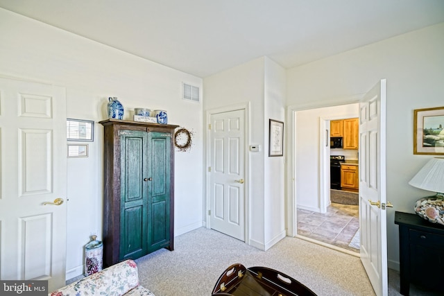 foyer entrance featuring visible vents, light colored carpet, and baseboards