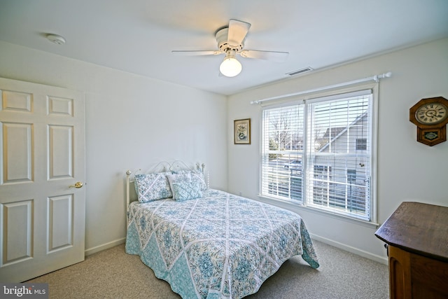 carpeted bedroom featuring visible vents, baseboards, and a ceiling fan