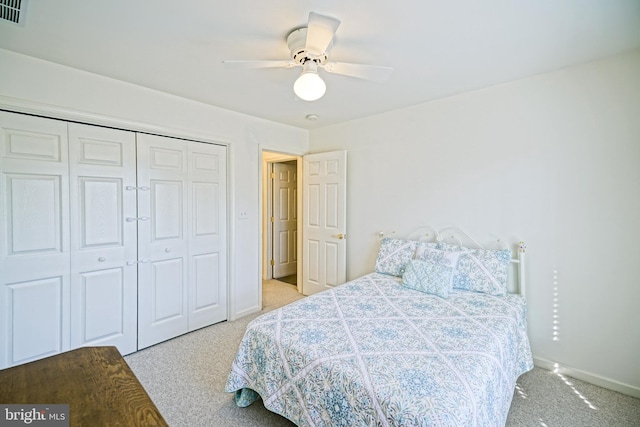 carpeted bedroom with a closet, visible vents, baseboards, and ceiling fan