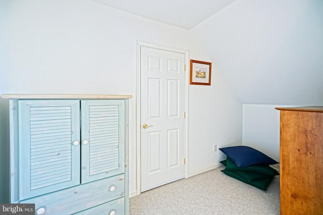 carpeted bedroom featuring vaulted ceiling and baseboards