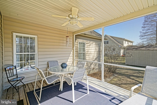 sunroom / solarium with plenty of natural light, wood ceiling, and a ceiling fan