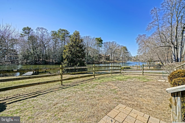 view of yard featuring fence and a water view