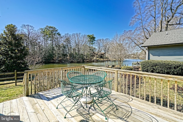 wooden terrace featuring a water view and outdoor dining space