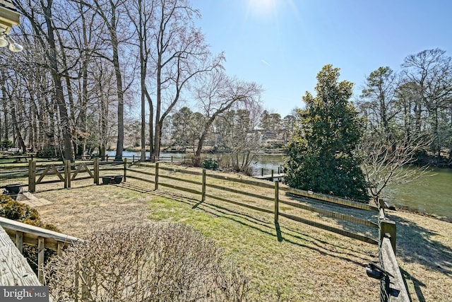 view of yard featuring a water view and fence