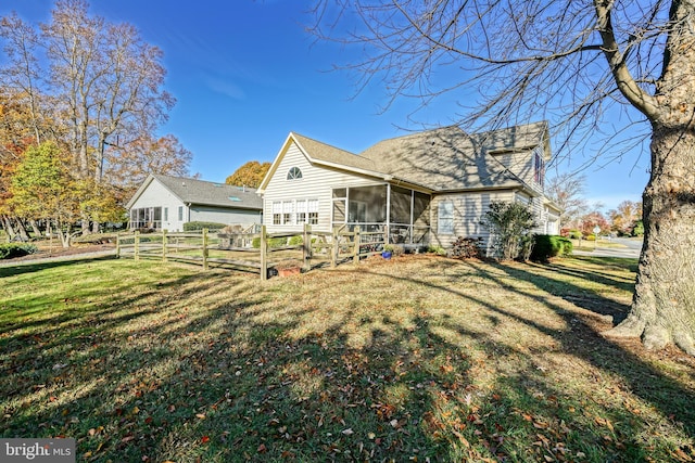 view of front of home with fence, a front lawn, and a sunroom