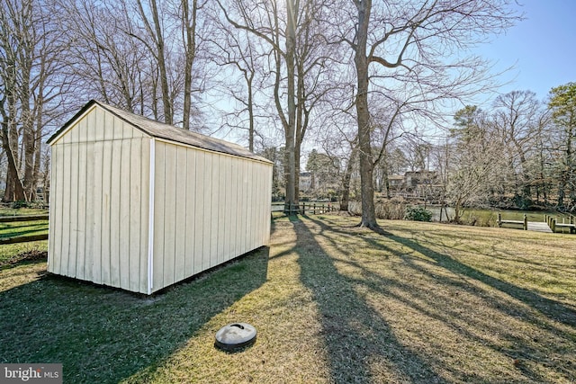 view of yard with an outbuilding, a storage unit, and fence