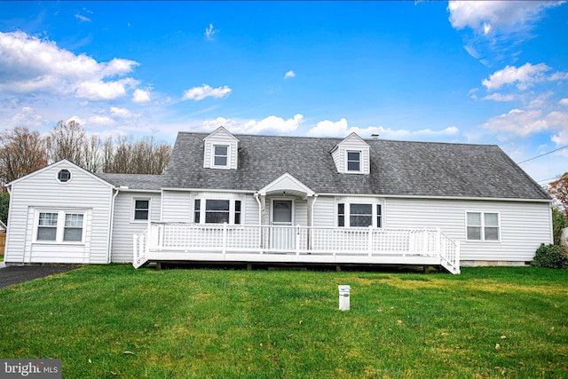 back of property with a wooden deck and a lawn