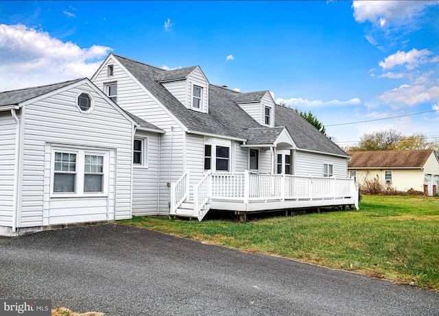 view of front of house with a front yard and a deck