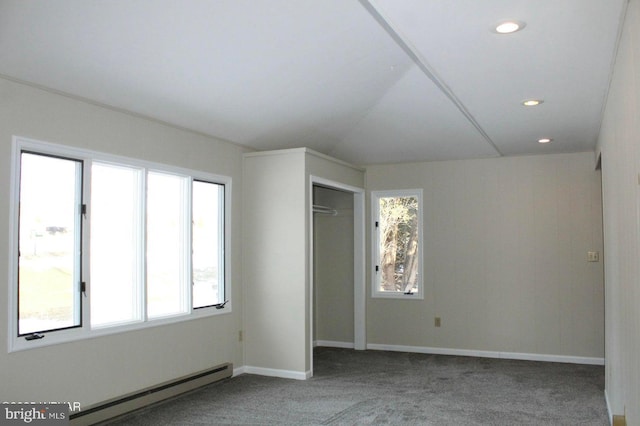 carpeted spare room featuring a baseboard heating unit