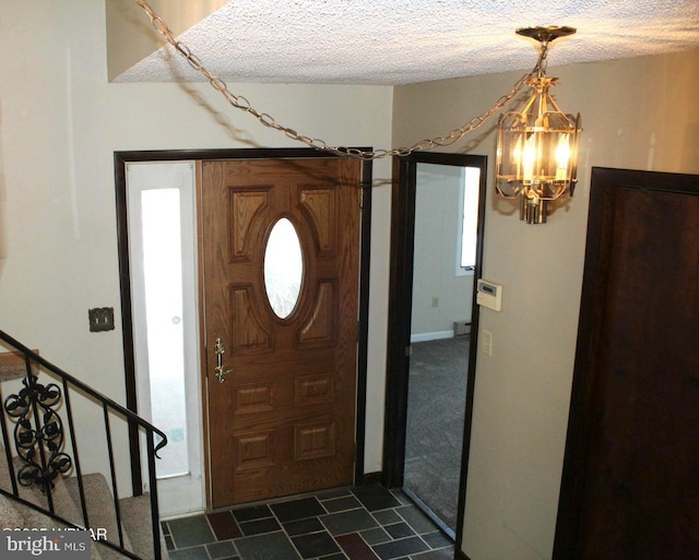 foyer with a notable chandelier and a textured ceiling