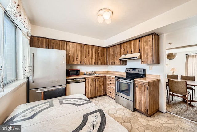 kitchen featuring extractor fan, plenty of natural light, stainless steel appliances, and light countertops