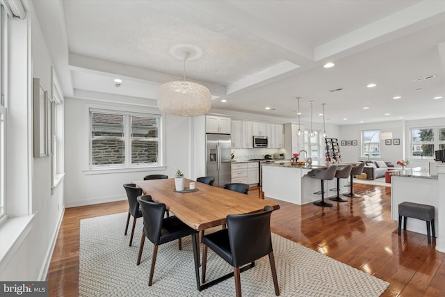 dining space featuring recessed lighting, beam ceiling, baseboards, and hardwood / wood-style flooring