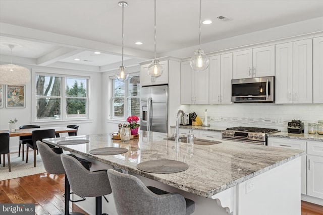 kitchen with visible vents, appliances with stainless steel finishes, dark wood-type flooring, and a sink