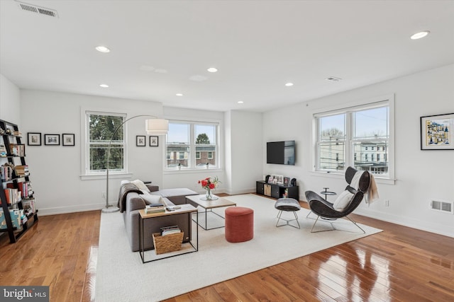 living area featuring hardwood / wood-style flooring, visible vents, and recessed lighting