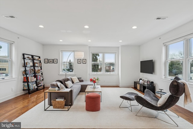 living room with recessed lighting, visible vents, plenty of natural light, and wood finished floors