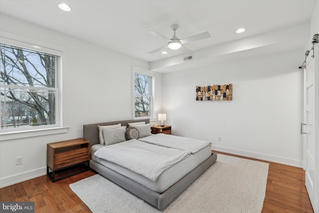 bedroom with recessed lighting, visible vents, ceiling fan, wood finished floors, and baseboards