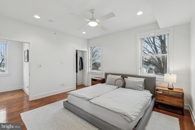 bedroom with multiple windows, baseboards, hardwood / wood-style floors, and recessed lighting