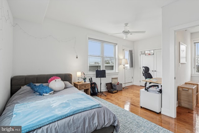 bedroom featuring a ceiling fan, baseboards, and wood finished floors