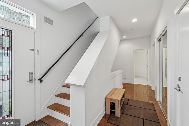 foyer entrance with baseboards, visible vents, wood finished floors, and recessed lighting