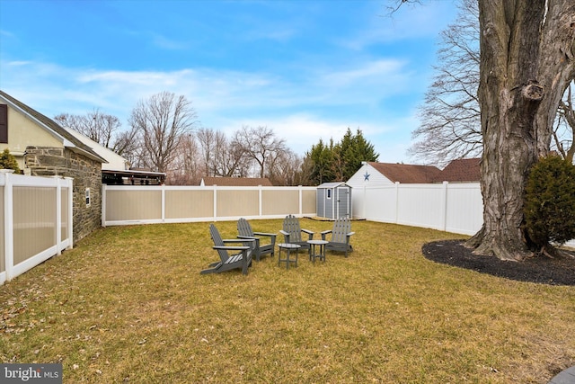 view of yard featuring a storage shed, an outbuilding, and a fenced backyard