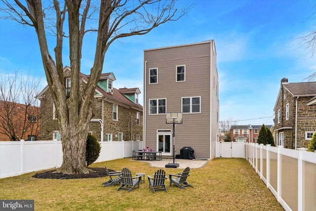 rear view of property featuring a fenced backyard, a patio, and a yard