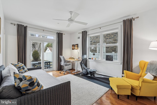 bedroom with access to exterior, ceiling fan, and wood finished floors