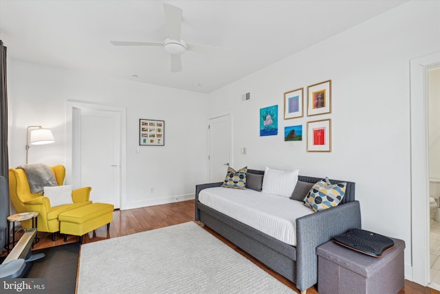 bedroom featuring baseboards, visible vents, ceiling fan, and wood finished floors