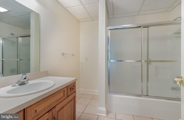 bathroom with enclosed tub / shower combo, a drop ceiling, tile patterned floors, and vanity