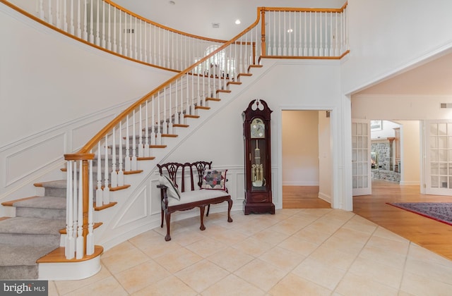 staircase featuring hardwood / wood-style flooring and a high ceiling