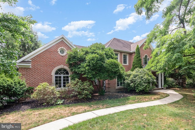 view of front of home featuring brick siding and a front lawn