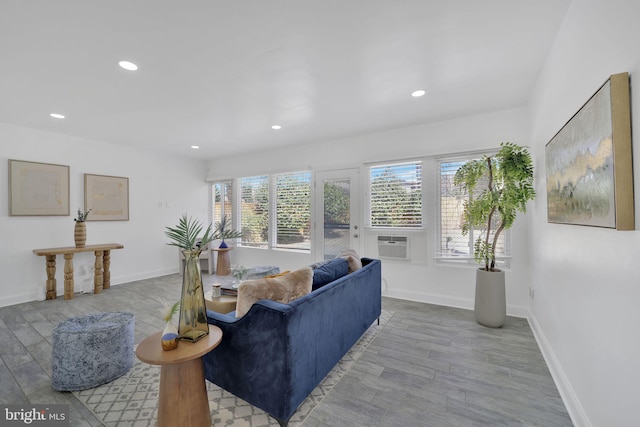 living room featuring baseboards, wood finished floors, and a healthy amount of sunlight