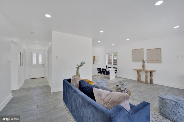 living area with light wood-type flooring, baseboards, and recessed lighting